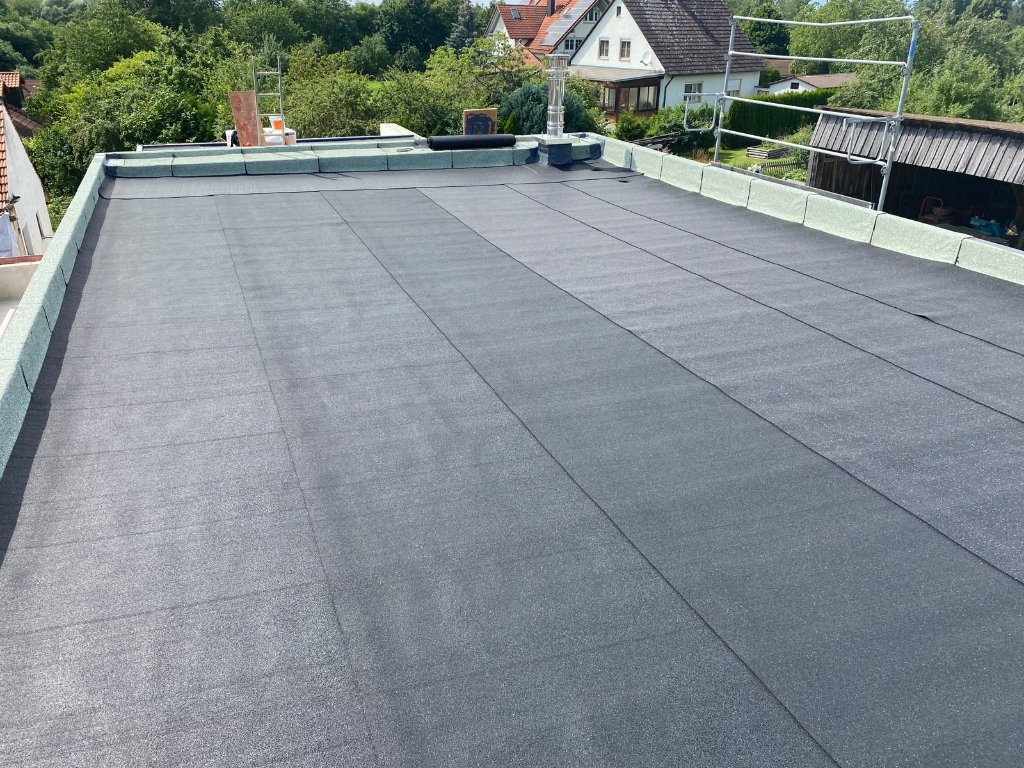 Fertig eingedecktes Schieferdach mit Edelstahl-Kamin